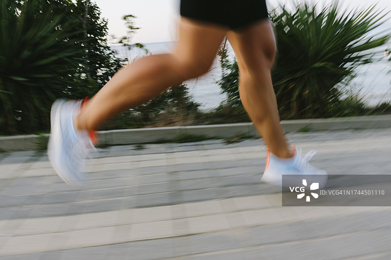 穿着白色运动鞋在人行道上跑步的女人图片素材