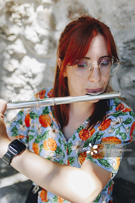 戴眼镜的红发女人练习长笛图片素材