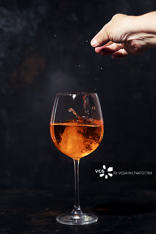 女人往玻璃杯里加冰块图片素材