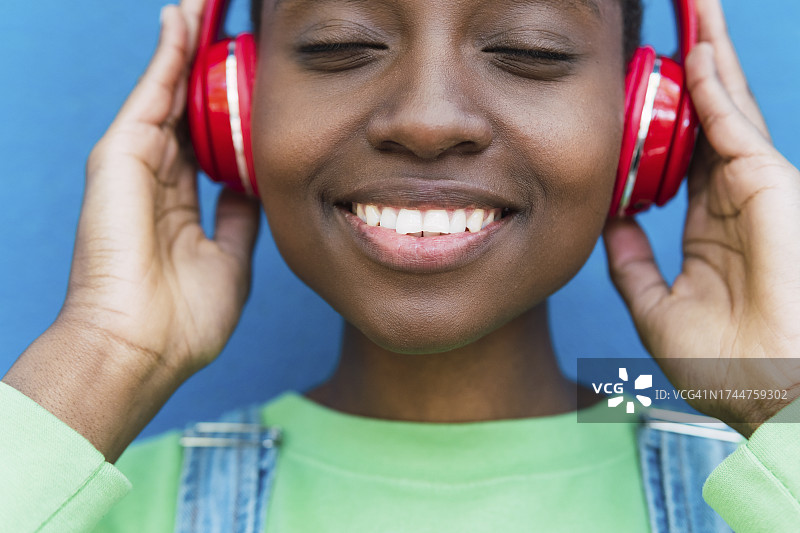 快乐的年轻女子戴着无线耳机听音乐图片素材