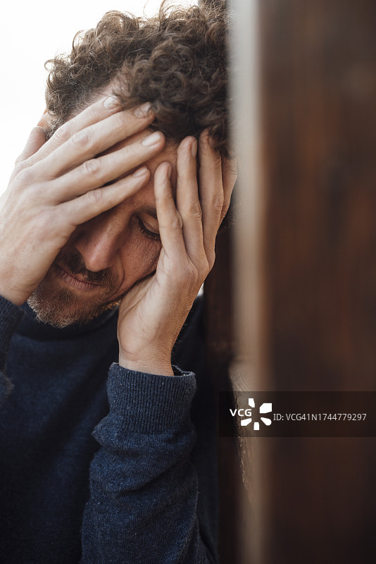 沮丧的男人靠在木头上图片素材