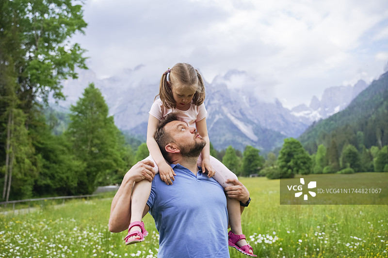 父亲和坐在肩膀上的女儿玩耍图片素材