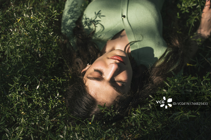 闭着眼睛躺在草地上的女人图片素材