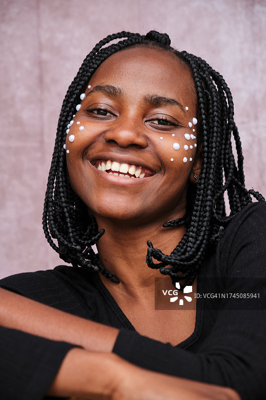 脸上贴着珍珠的非洲女子肖像，看着镜头图片素材