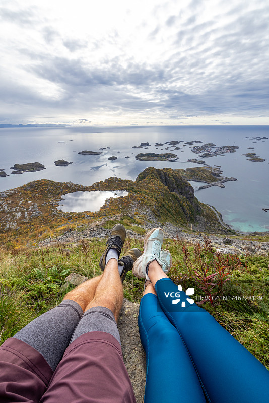 徒步者在岩石上休息并欣赏秋景的POV视角图片素材