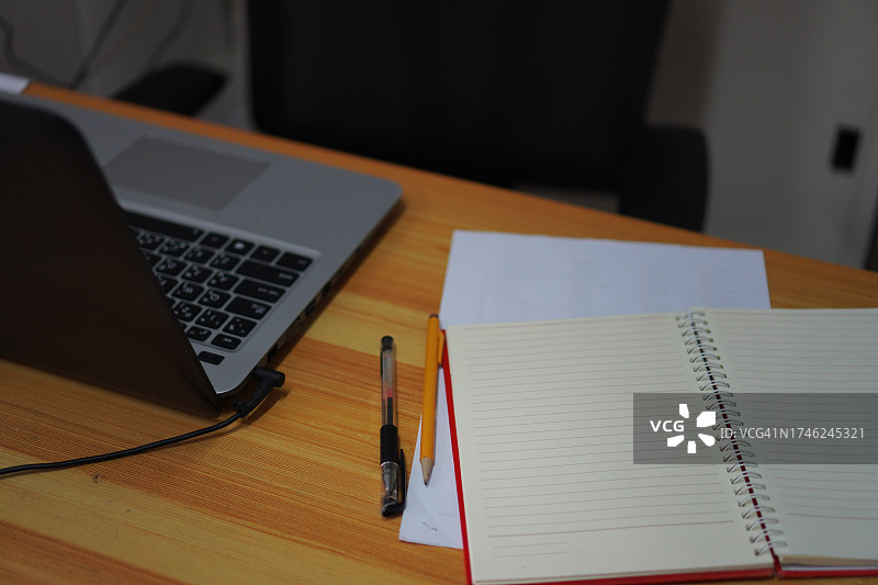 桌子上的笔记本纸、钢笔和铅笔图片素材