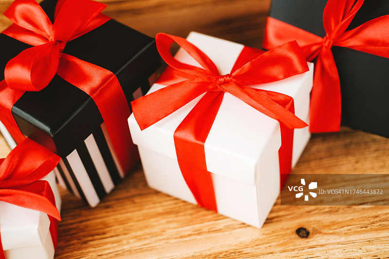 带红色丝带蝴蝶结的黑白礼品盒特写图片素材