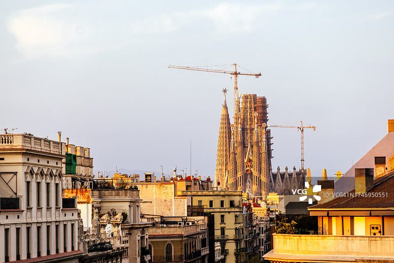 日落时分西班牙加泰罗尼亚巴塞罗那圣家族教堂和城市天际线图片素材
