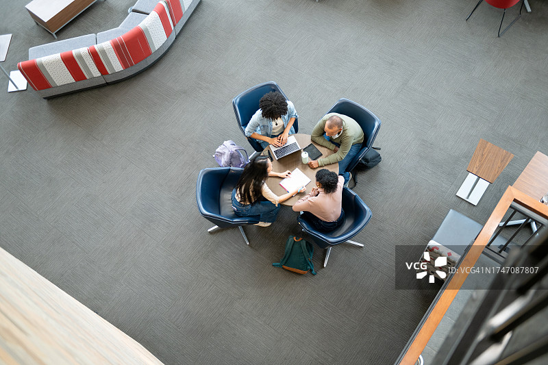 大学生在圆桌旁工作的俯视图图片素材