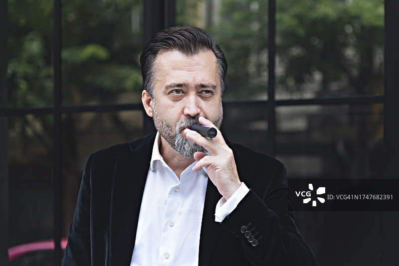 在户外吸烟的男商人图片素材