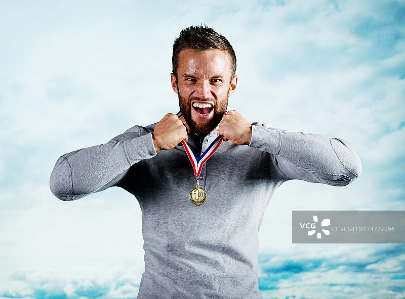 兴奋的年轻人展示他的奖牌图片素材