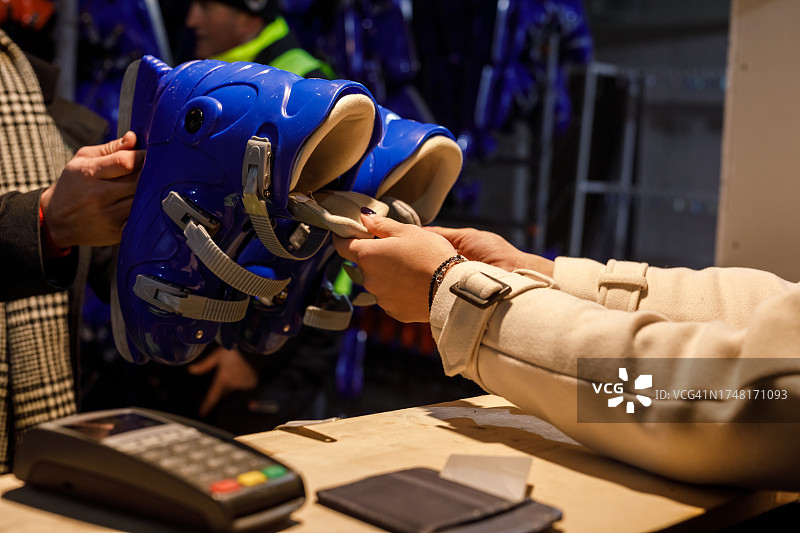 年轻女人在溜冰场柜台上租溜冰鞋图片素材