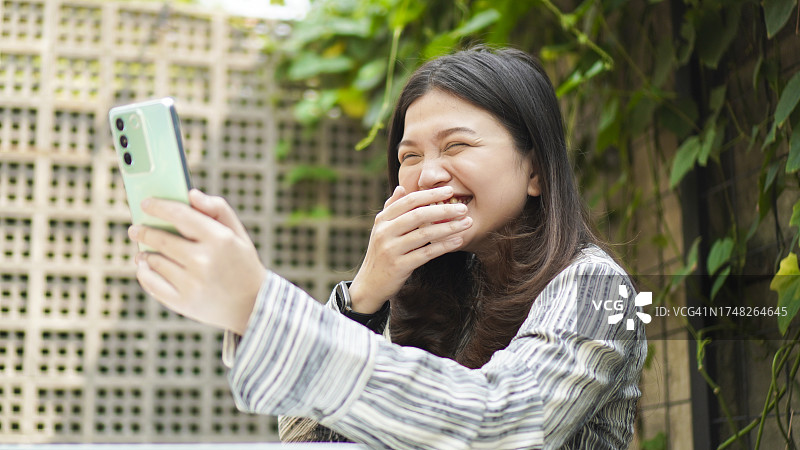 使用智能手机进行电话会议的年轻女人图片素材