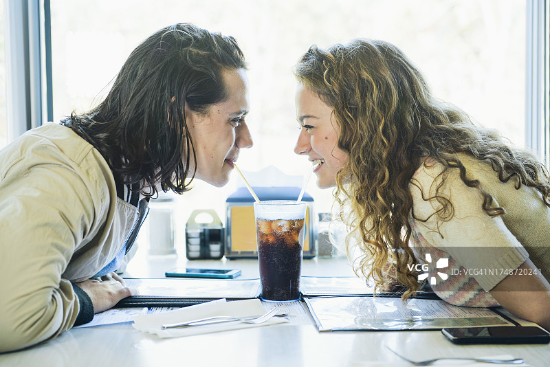 青少年男女在餐馆的摊位上分享苏打水图片素材