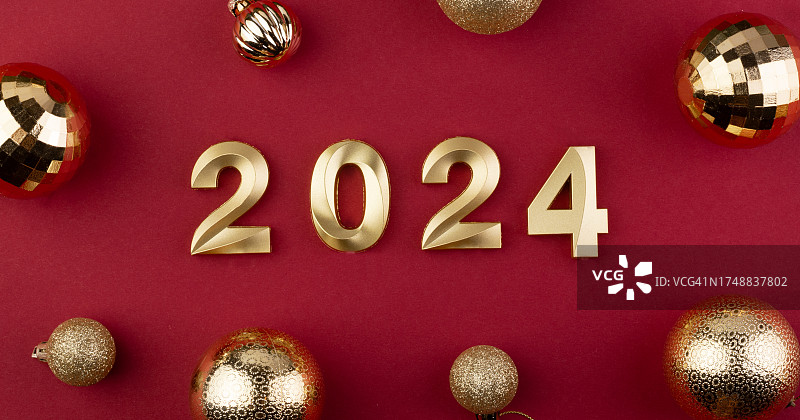 红色背景上的2024年符号与金色圣诞球图片素材