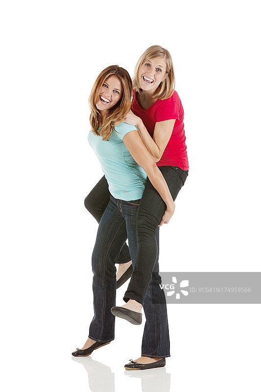 女人骑在朋友的肩膀上图片素材