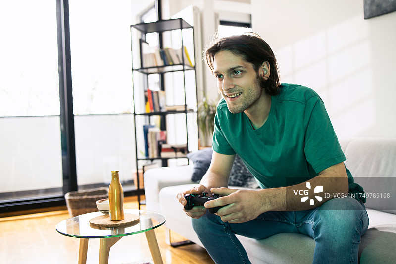 年轻男子玩电子游戏的肖像图片素材