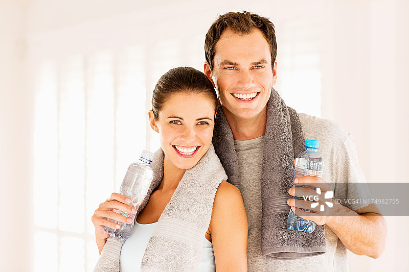 年轻情侣锻炼后拿着水瓶图片素材