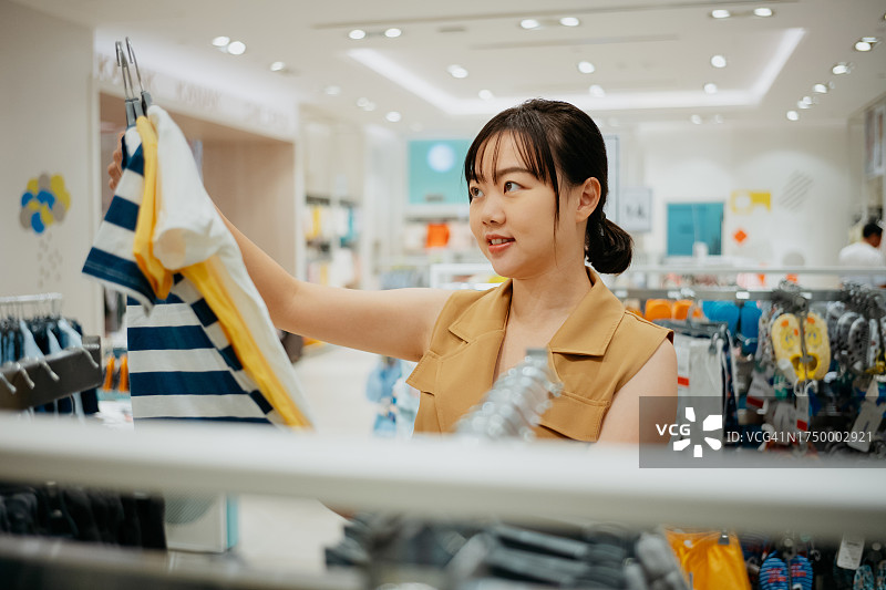 母亲在百货商店为孩子购买服装图片素材