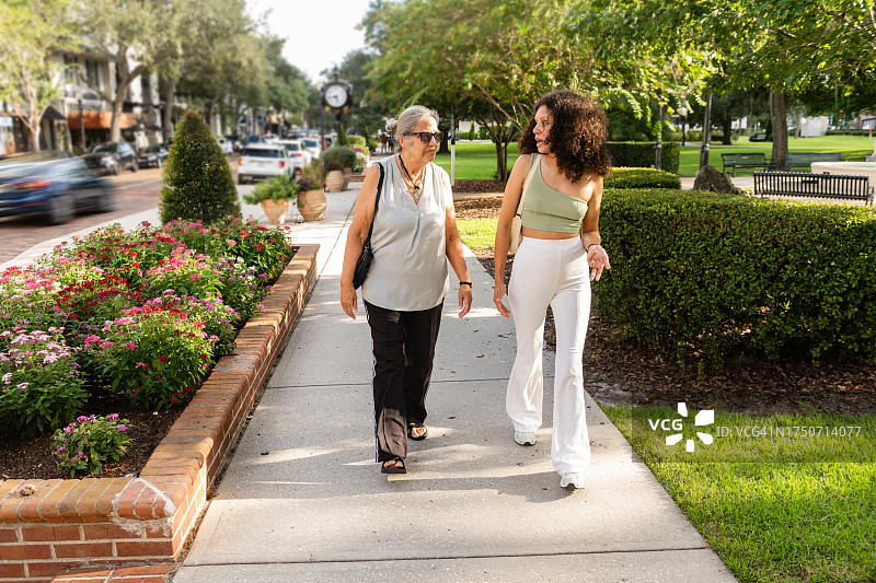 老年妇女与成年孙女在佛罗里达州冬季公园散步交谈图片素材