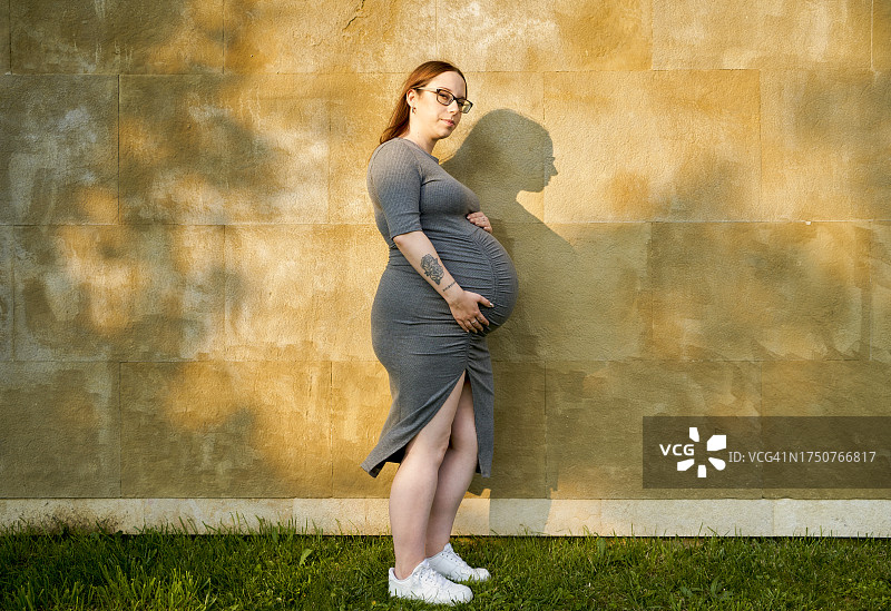 孕妇在城市户外享受，看着相机图片素材
