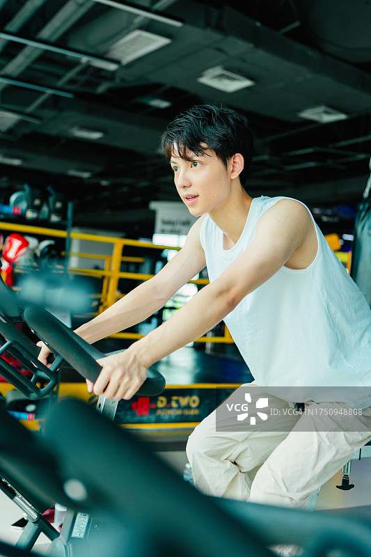 男子在健身房骑动感单车训练——健康的生活方式，身心健康训练，幸福和健康图片素材