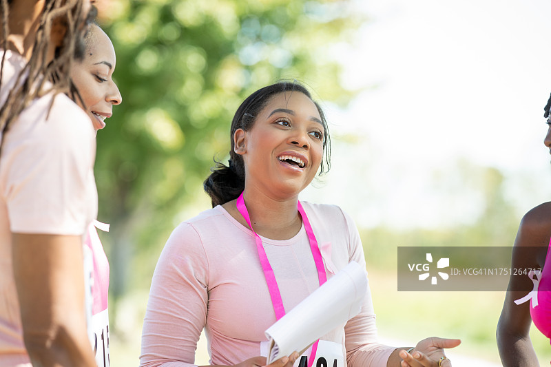 年轻女子积极帮助他人报名参加乳腺癌防治慈善马拉松图片素材