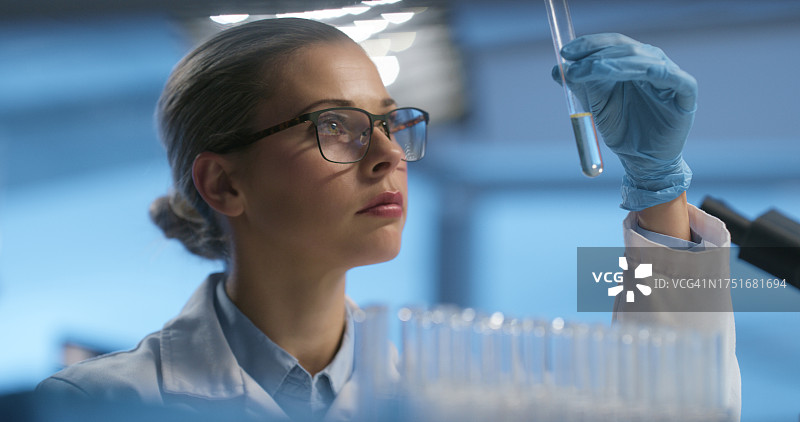 试管、面部和科研女性分析液体溶液、药物和审查实验室产品、生物技术或评估。实验室、研究科学家和化学家解决化学工程问题图片素材