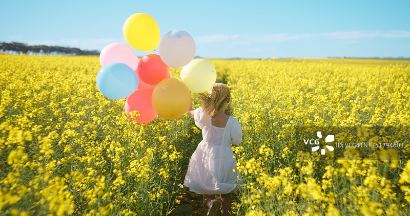 春季郊外，女孩带着气球散步，庆祝生日或享受自由图片素材