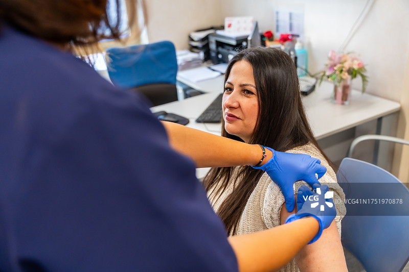 护士在医疗中心为流感疫苗接种活动进行注射，抵抗冬季流感图片素材