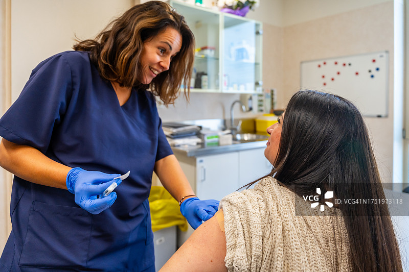 护士为患者注射流感疫苗，参与医疗中心冬季疾病防治活动图片素材