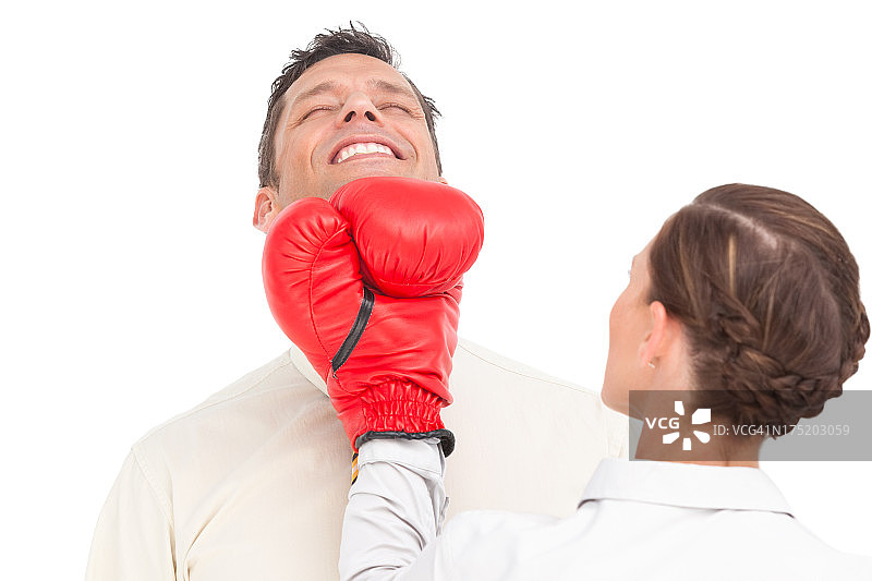 戴着拳击手套的商务女人击打商人图片素材