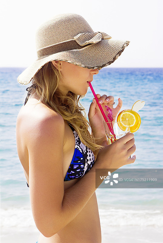 年轻漂亮的女人在喝鸡尾酒图片素材