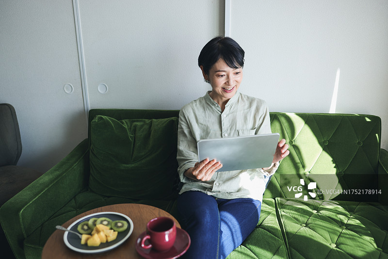 在家使用平板电脑的中年妇女图片素材