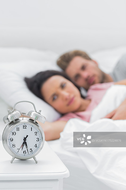 情侣在床上，闹钟在旁图片素材
