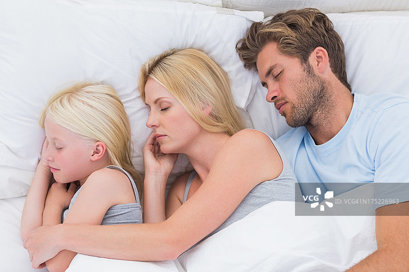 幸福的一对与女儿一起睡觉图片素材