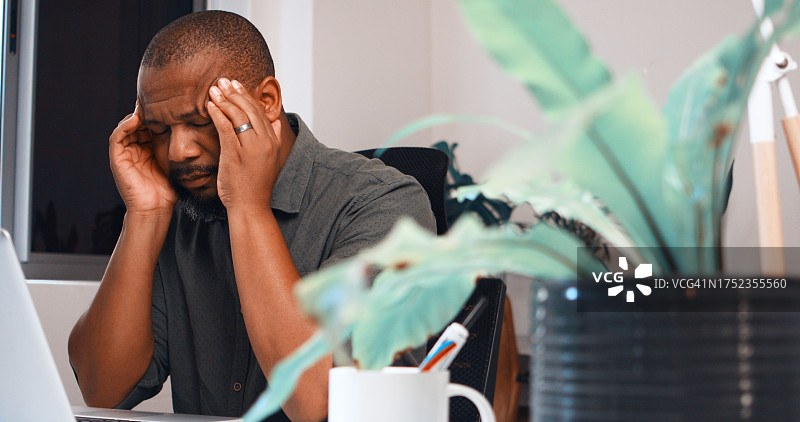 黑人男子，在办公室用笔记本电脑工作时感到疼痛和头痛，因压力、眩晕和脑雾而导致业务危机。沮丧、生病和疲惫的工人在电脑前工作，感到疲劳、倦怠和404故障图片素材