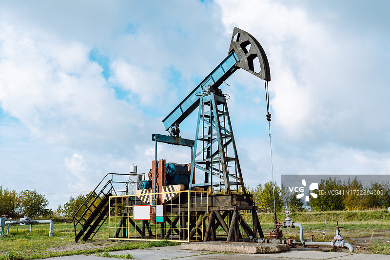 油气开采：油田抽油机在农田中作业图片素材