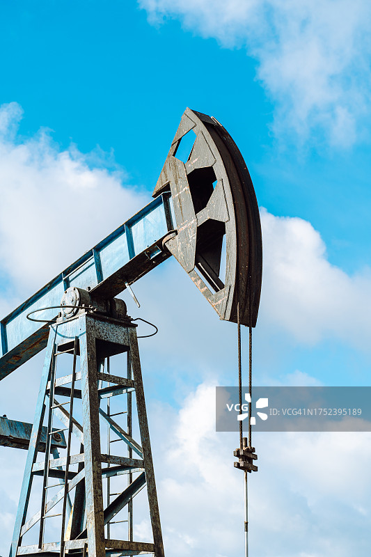 蓝色天空下的蓝色抽油机。低角度图片素材
