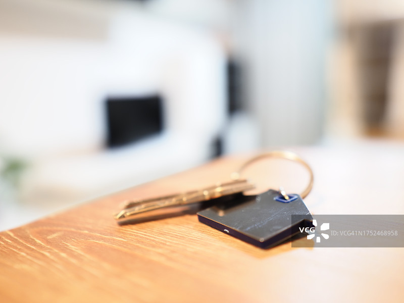 木质背景上的房子钥匙链金属钥匙图片素材