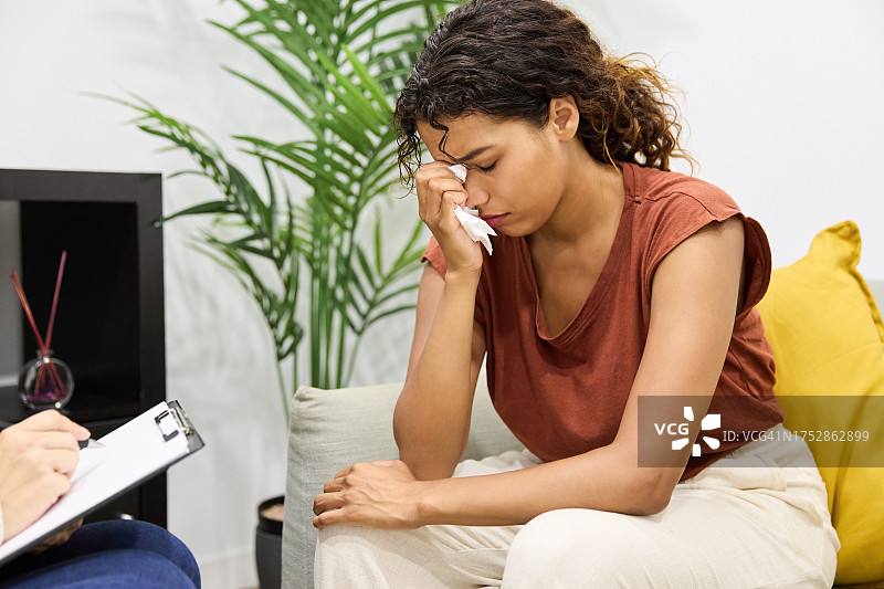 接受治疗时哭泣的沮丧西班牙裔女人图片素材