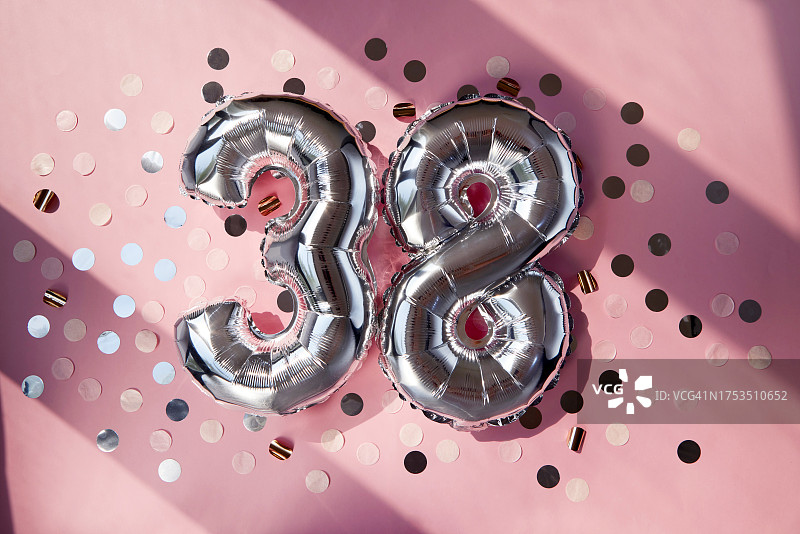 阳光粉色背景下的银色38周年气球图片素材