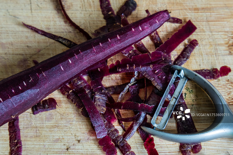 在砧板上削紫色胡萝卜皮图片素材