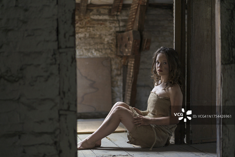 年轻女人坐在废弃的建筑物里图片素材