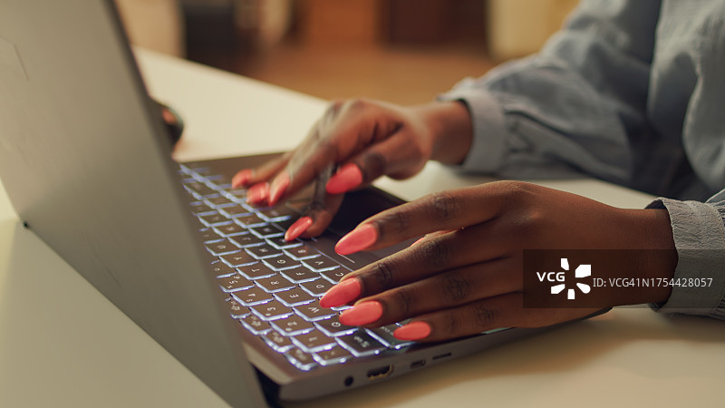 在桌旁使用笔记本电脑的女子（腰部视角）图片素材