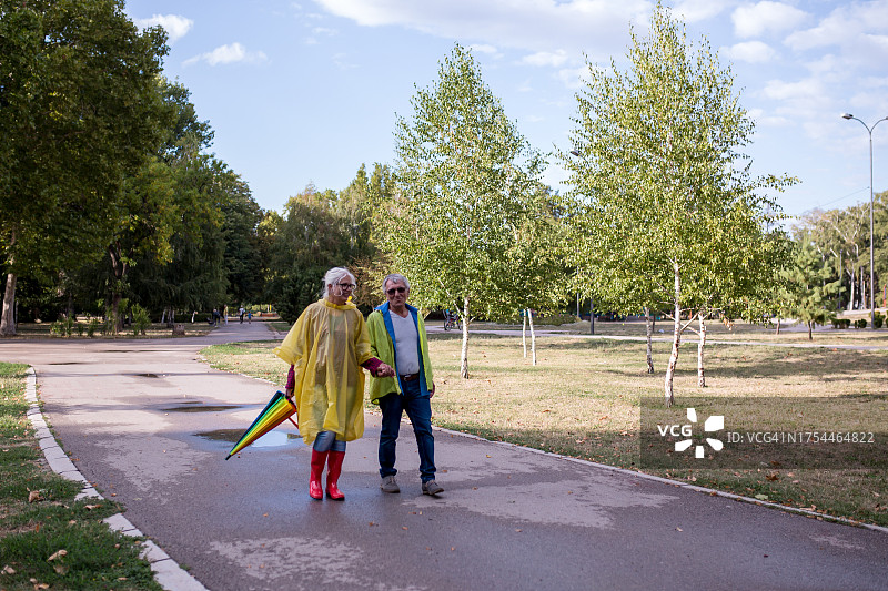 在雨天穿着雨衣的快乐老年夫妇图片素材