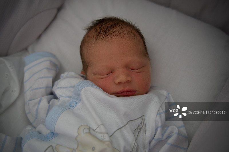 在家中床上睡觉的可爱男婴的俯视图图片素材