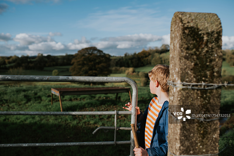 儿童穿过大型田野的敞开式农业大门图片素材