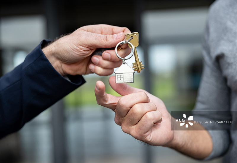 房地产经纪人将新房钥匙交给男人的特写图片素材