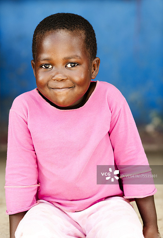 快乐的小女孩坐在房子外面图片素材
